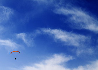 Silhouette of skydiver at sky