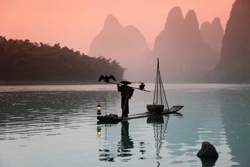 Photo sur Plexiglas Guilin YANGSHUO - 18 JUIN : Homme chinois pêchant avec des oiseaux de cormorans dedans