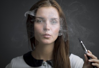 Elegant woman smoking e-cigarette with smoke