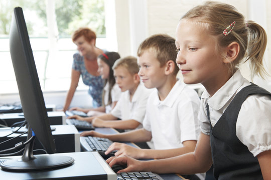 Group Of Elementary Pupils In Computer Class With Teacher