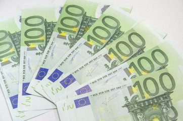 Close-up of 100 Euro banknotes isolated on white background.