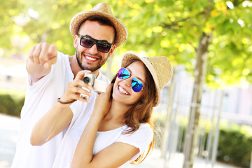 Joyful couple taking pictures in the city