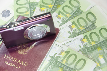 Close-up of 100 Euro banknotes and passport with camera isolated