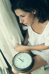Obraz na płótnie Canvas beautiful young woman holding a big clock