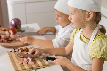 Obraz na płótnie Canvas Two young children in chefs uniforms