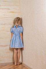Little girl being punished standing in the corner