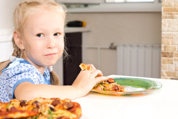 Cute little girl enjoying a homemade pizza