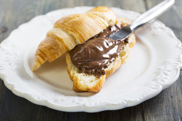Plate with croissant and chocolate.
