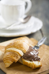 Croissant with chocolate on a sheet of parchment.