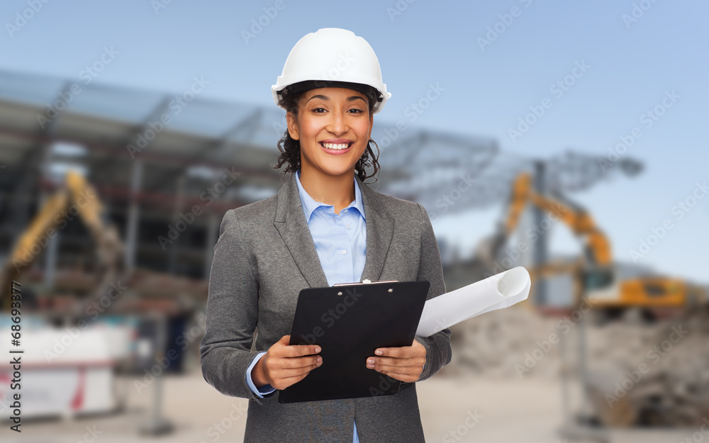Wall mural smiling architect in helmet with blueprint