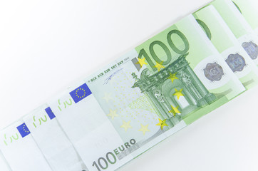 Close-up of 100 Euro banknotes isolated on white background.