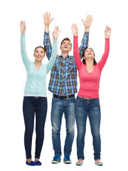 group of smiling teenagers with raised hands