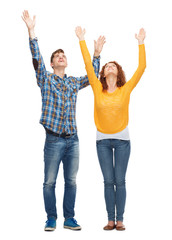 Obraz premium smiling teenagers with raised hands