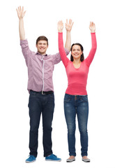 Obraz premium smiling teenagers with raised hands