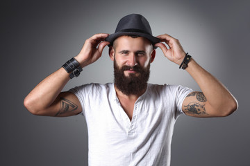 Portrait of handsome bearded man in hat standing , isolated on