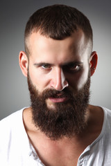 Fototapeta premium Portrait of handsome bearded man standing, isolated on grey