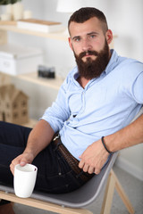 Young man sitting with  laptop and a tea cup at home