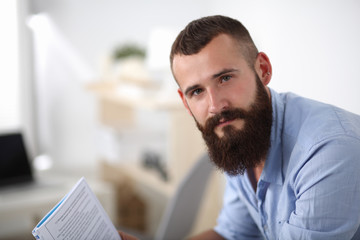 Naklejka premium Young businessman sitting on chair in office