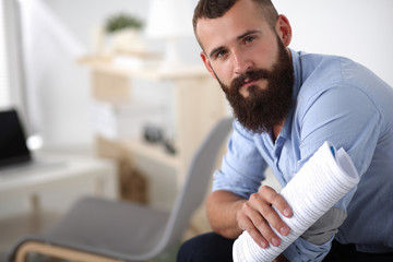 Fototapeta premium Young businessman sitting on chair with book in office