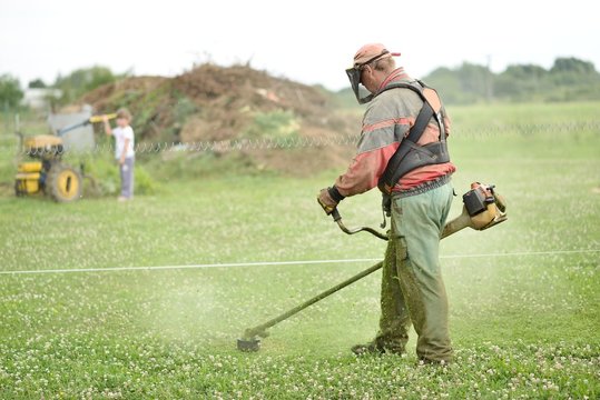jardinier avec une tondeuse &agrave; essence