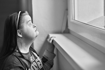 trisomique femme regarde par la fenêtre
