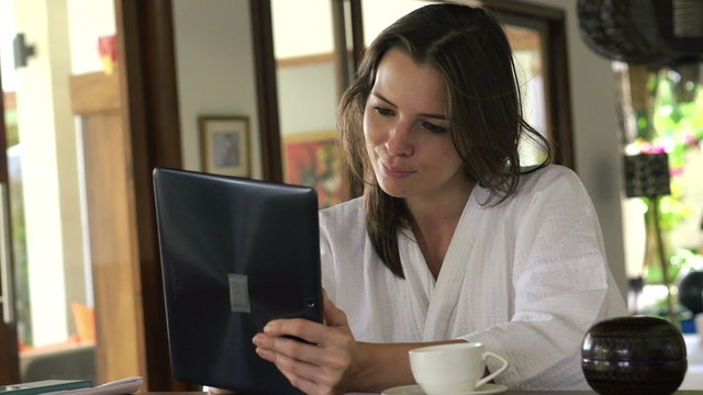 Woman with tablet computer sit by the table at home
