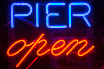 A blue and red Pier Open sign