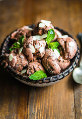 Chocolate ice cream with mint and almonds on wooden background