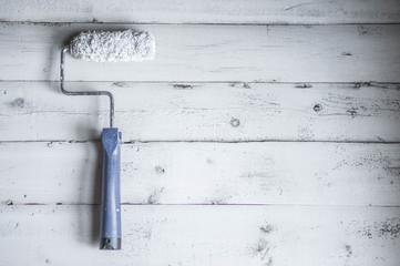 Paint roller on wooden background