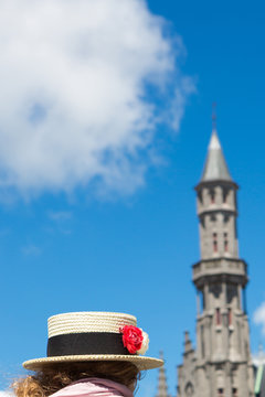 Vintage hat and red flower with city hall in Brugge