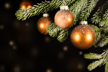 Christbaumkugeln mit Schnee vor schwarzem Hintergrund