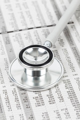 Stethoscope rest on stock price detail financial newspaper