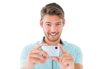 Handsome young man taking photo with smartphone