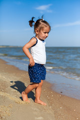 Fototapeta na wymiar girl on the beach by the sea