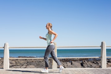 Fototapeta na wymiar Fit mature woman jogging on the pier