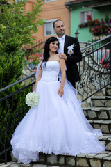 Fototapeta premium Young wedding couple posing on a staircase