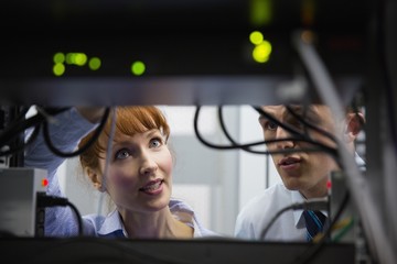 Team of technicians talking and looking at server