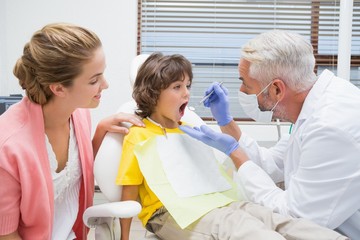 Pediatric dentist examining a little boys teeth