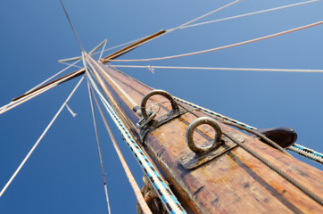 Old wooden mast with crosspieces and backstays, view from deck