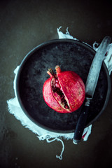 Splitting open a pomegranate with a knife