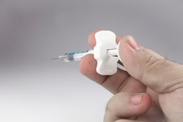 Hand with a syringe in position to inject