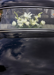 flowers decorating an old black luxury car
