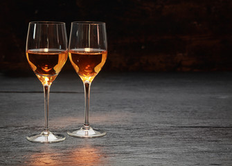 Two wine glasses standing on stone surface