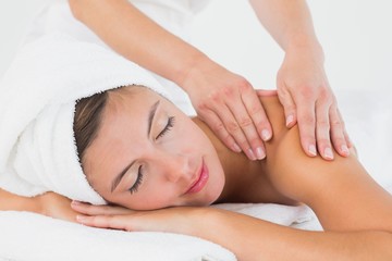 Fototapeta na wymiar Attractive young woman receiving shoulder massage at spa center