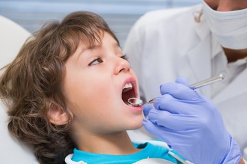 Pediatric dentist examining a little boys teeth