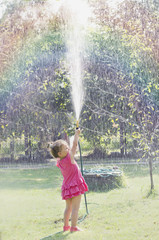 Dziewczynka w różowej sukience oblewająca się wodą