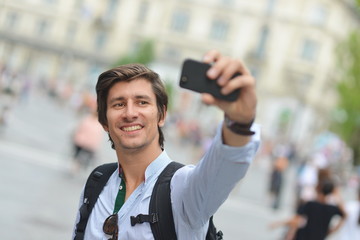 Student / tourist taking self portrait in the European city