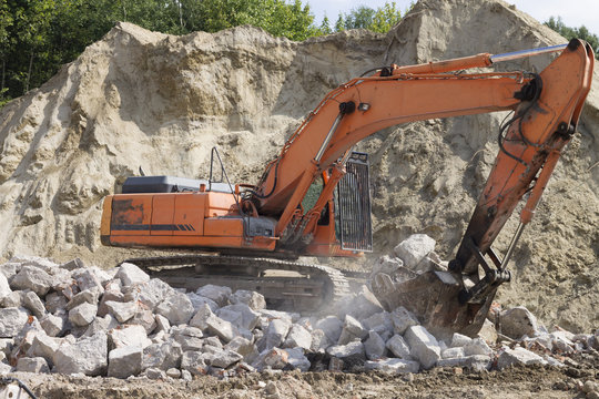 Working excavator during the removal of stones