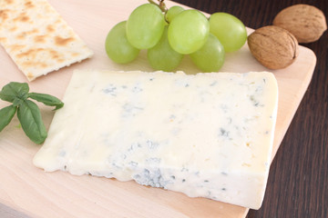 Gorgonzola blue cheese with grapes  on wooden chopping board