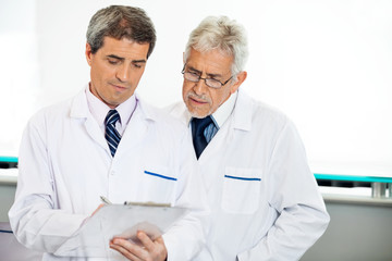 Fototapeta premium Technicians Discussing Over Clipboard